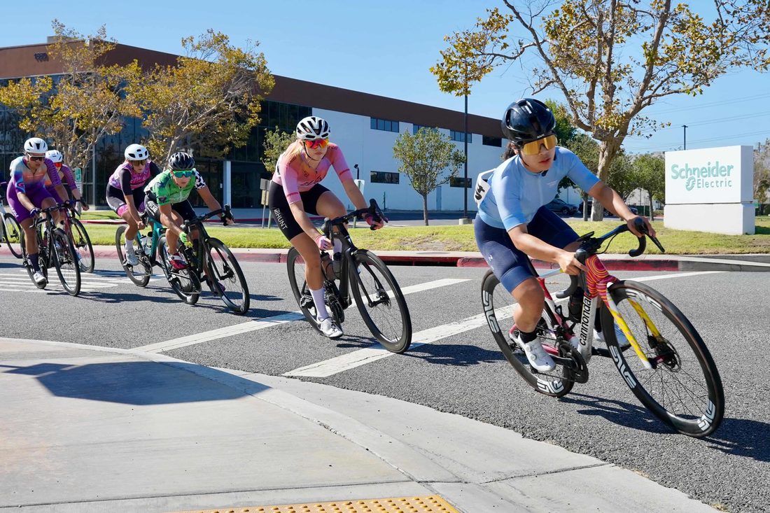 Weijun Li leading a group of riders through a corner during a criterium race
